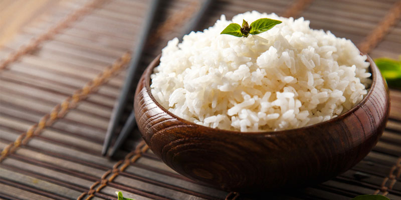 cooked white rice in a wooden bowl. 
