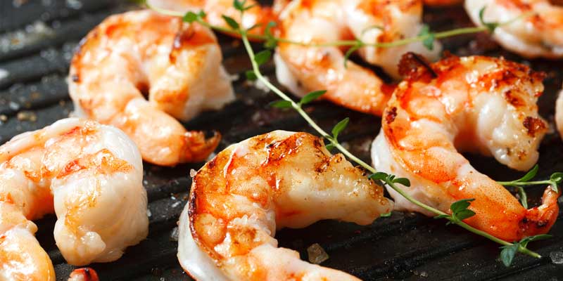 grilled shrimp with sprigs of herbs