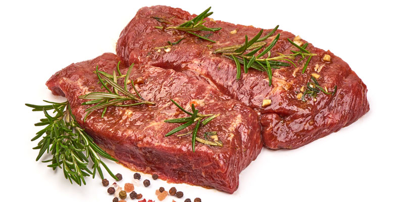 raw steak with butter, rosemary, pepper corns. 