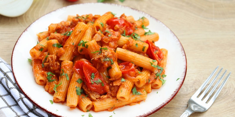 rigatoni pasta with tomato tomato sauce served on a white plate.